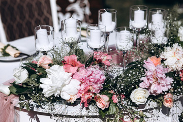 a wedding table with cutlery, candles and flowers.