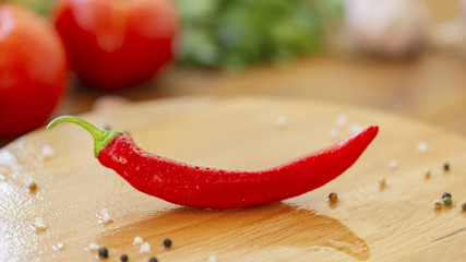 Hot chili and other ingredients for cooking on wooden background