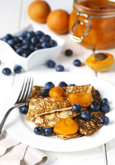 Homemade crepes served with apricot jam fresh blueberries.