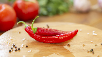 Hot chili and other ingredients for cooking on wooden background