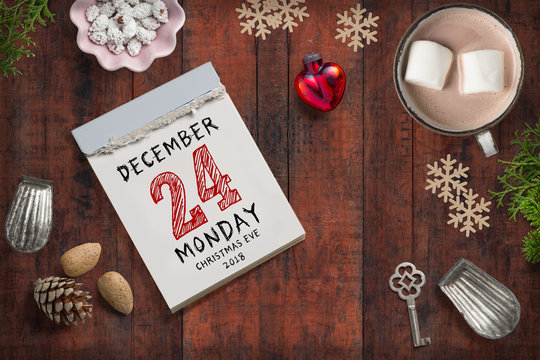christmas decoration on wooden background and tear off calendar with the 24th of december 2018 on top