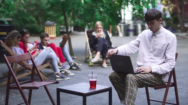 Young man finish his work at netbook and goes away