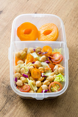 Healthy meal prep container with food ready to eat.Chickpea salad on wooden table. Top view. Copyspace