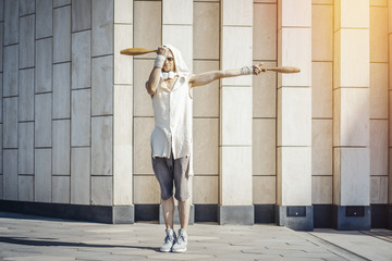 Attractive athletic man practicing yoga with maces outdoors in modern park.