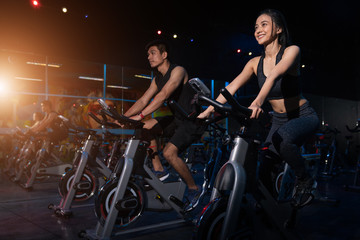 Young People - Group of women and men - Doing sport biking in the gym for fitness - obrazy, fototapety, plakaty