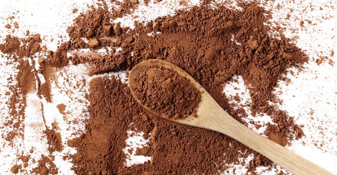 pile cocoa powder and wooden spoon isolated on white background, top view