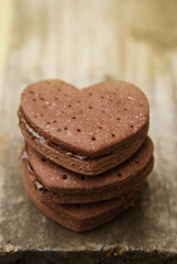 Delicious heart shape homemade chocolate cookies on rustic wooden background. Sweet chocolate dessert or snack.