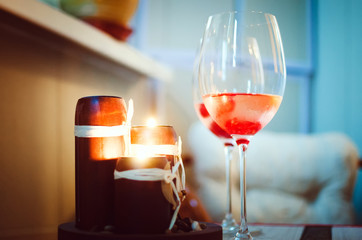 Glasses of wine and lighted candles. Romantic scenery.
