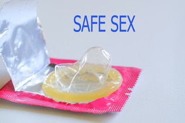 Close up of a yellow condom on white background