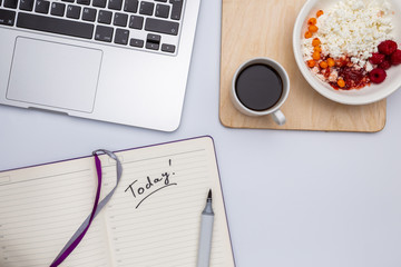 Top view with copy space, Office white desk table with computer, coffee cup espresso, curd in a plate with raspberry jam, breakfast