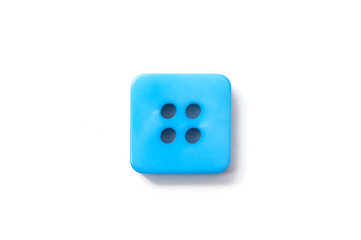 closeup of blue square sewing buttons on white background
