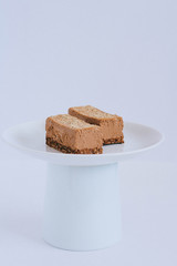 Chocolate raw dessert from mousse on a nut basis, on a cake stand