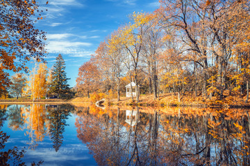 Sunny autumn landscape with blue sky over the lake