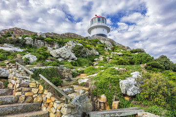 Old lighthouse (1857) sits on top of cliffs of Cape Point in Cape of Good Hope Nature Reserve on southern tip of Cape Peninsula in South Africa. The Atlantic and Indian oceans converge at Cape Point. © dbrnjhrj