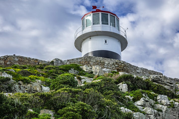 Old lighthouse (1857) sits on top of cliffs of Cape Point in Cape of Good Hope Nature Reserve on southern tip of Cape Peninsula in South Africa. The Atlantic and Indian oceans converge at Cape Point. © dbrnjhrj