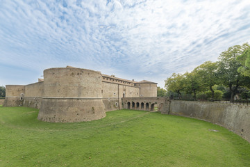 Fototapeta na wymiar the rocca, or castle, immersed in the green of the military architecture of the fifteenth century. square, with four great cylindrical towers, the various slits and ports for cannon