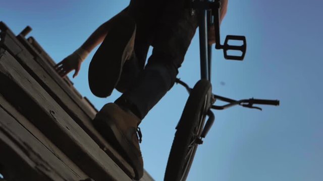 Silhouette of jumper, performing BMX mountain bike sport jump