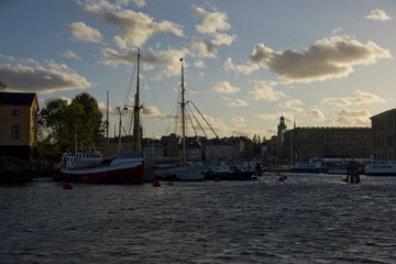 Fototapeta na wymiar Boats and landmarks at Stockholm waterfront at sunset