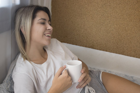 Girl drinking coffee at breakfast in the morning in bed