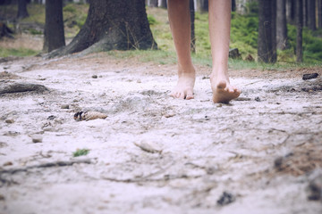barefoot child walk alone by path, explore the forest. Outdoor hiking activities.