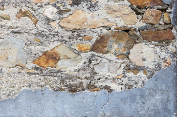 Gray textured stone wall with blue peeling paints. Dirty painted stone background