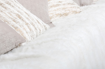 Many pillows lie on the couch, which is covered with a large plush veil