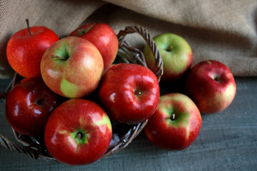 Jabła w koszyku na tle tkaniny © Monika