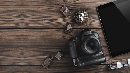 Top view of travel concept with digital camera, tablet, eyeglasses and biscuits on wooden...