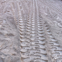 Tire marks in the sand of construction yard square