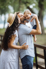 Fototapeta premium Mother father and little son in the summer park