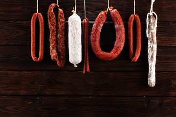 sausages hang from a rack at market. Country dark style. Traditional food. Smoked sausages meat...