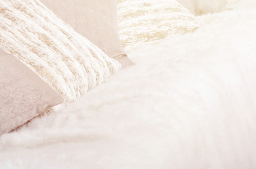 Many pillows lie on the couch, which is covered with a large plush veil