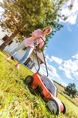 Woman mowing green grass