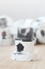 Several plastic nozzles from a paint sprayer that lie on a wooden surface against a gray wall...