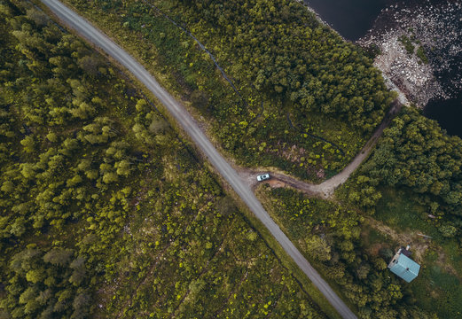 House in the forest with car leaving the house seen from the sky, Lapland Finland