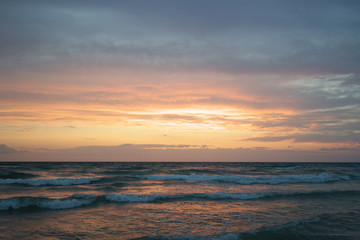 Beach at sunset with big clouds and colors in Salento - Italy