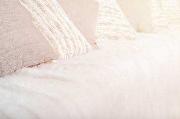 Many pillows lie on the couch, which is covered with a large plush veil