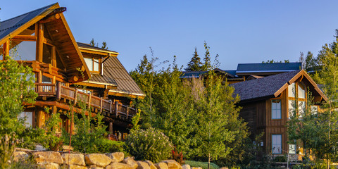Two cabins in luxury neighborhood at sunset pano © Jason