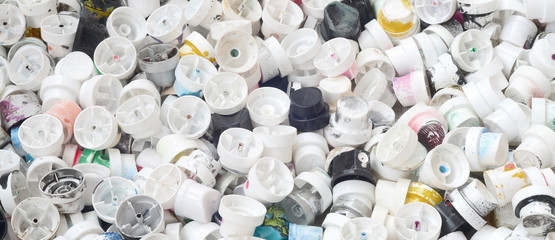 A large number of caps from cans of aerosol paint for graffiti. Smeared with colored paint nozzles...