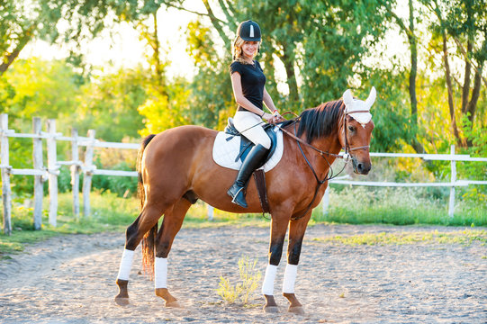 A beautiful girl rider walks with a horse. Horse theme