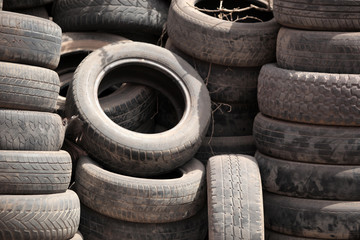 close up of a pile of used black dusty tires, outdoors, on street in the Gambia, with natural light