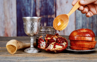 Fototapeta na wymiar Honey, apple and pomegranate for traditional holiday symbols rosh hashanah jewesh holiday on wooden background.