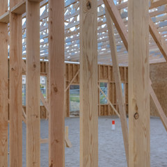 Obraz na płótnie Canvas Vertical wooden beams with sandy ground square