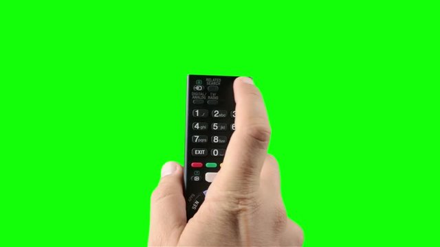Hand pushing the ON OFF button on the remote control against green screen