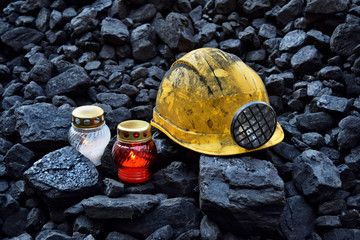 Vigil light, candle with mining helmet on cheap of coal - obrazy, fototapety, plakaty