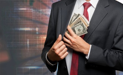 Businessman hiding dollars banknotes in the pocket of jacket