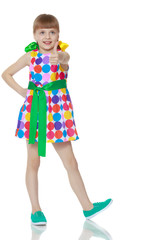 A little girl in a dress with a pattern from multi-colored circl