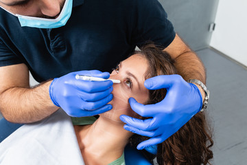 Peaceful young patient with correction lines on the face in an examination room.