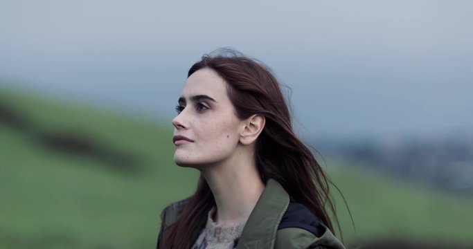 Millennial female looking up to a grey sky