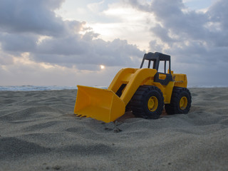 Obraz na płótnie Canvas toy wheel loader on the sand at the beach